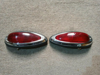 A pair of original Porsche 356a/b/c Rear light units 1957-65 .Fitted with USA all red rear lens . All parts have been cleaned and then re-assembled , new bulbs fitted and tested to be in full working order . They have original bulb holders , USA all red original lenses and original chrome trims with numbers SWF K3260 , new screws fitted and original rubbers slightly cracked , but all very usable and ready to install .