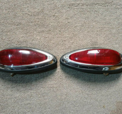 A pair of original Porsche 356a/b/c Rear light units 1957-65 .Fitted with USA all red rear lens . All parts have been cleaned and then re-assembled , new bulbs fitted and tested to be in full working order . They have original bulb holders , USA all red original lenses and original chrome trims with numbers SWF K3260 , new screws fitted and original rubbers slightly cracked , but all very usable and ready to install .