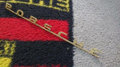 A stripped Porsche Emblem, 5 studs, for Porsche 356B T5 models . 254 mm in length , with the R on reverse . Needs a little work ,not perfect would suit ratty 356.